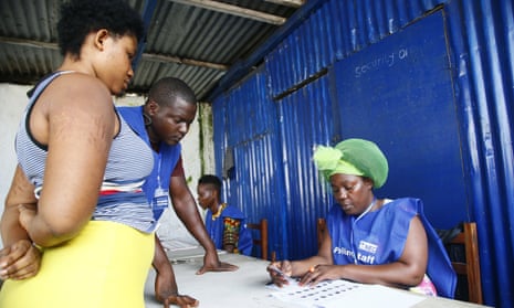 Polling staff in Monrovia, the Liberian capital, check a voter’s name and ID.
