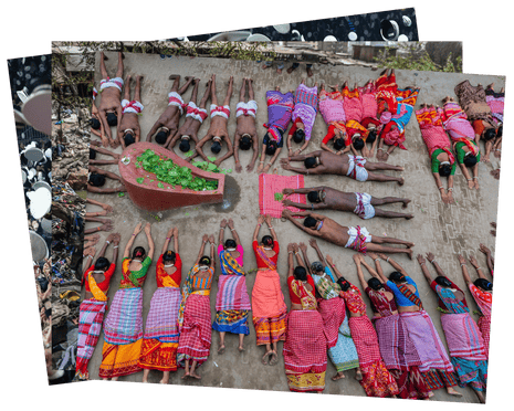 People in colourful clothes lie prostrate with their arms pointed forwards in a circle