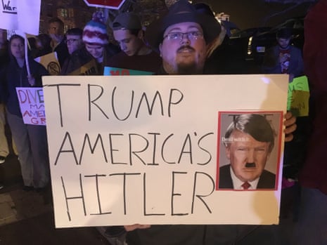 A protestor in Portsmouth, New hampshire, holds a poster declaring “Trump America’s Hitler”.