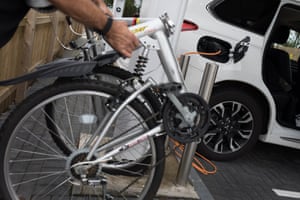 David Kidd folds up his bike while his Mitsubishi Outlander charges.