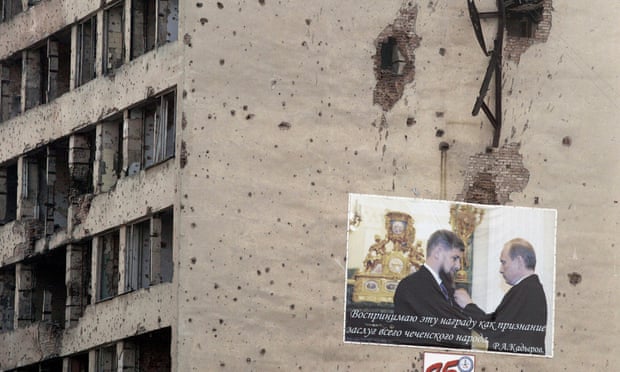 A poster on a bullet-riddled wall in Grozny showing Vladimir Putin presenting a medal to the Chechen leader, Ramzan Kadyrov.