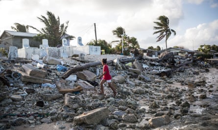 A girl walks past a cemetery in the Marshall Islands that was inundated by the seawater during storm surges.