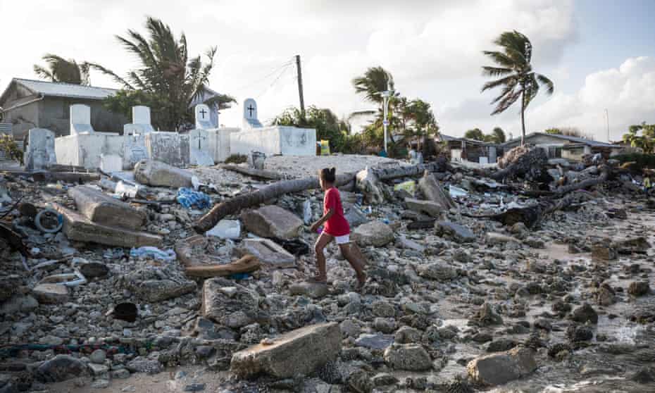 A girl walks past the cemetery in Jenrok village, on the Majuro atoll