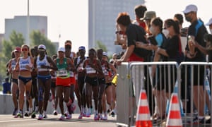Spectators on the road watch the leading group approach.