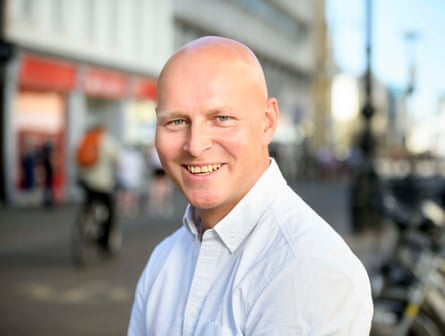 Man smiles standing on a high street
