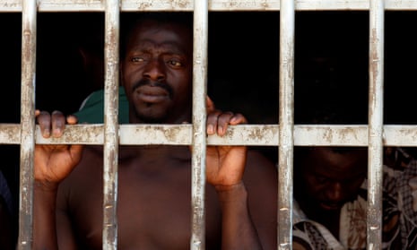 A man looks out of a barred door at a detention centre for migrants in Gharyan, Libya.