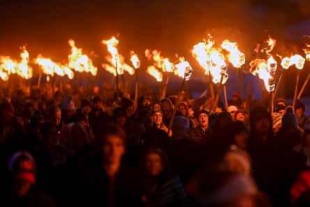 People carrying torches at night.