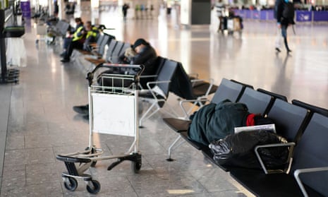 People are seen sleeping on the chairs at Heathrow airport
