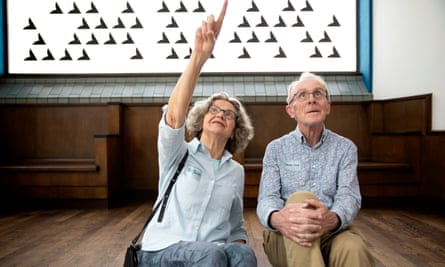 Riet Jacobs and Jeroen Smit sit on the floor with Jacobs pointing upwards