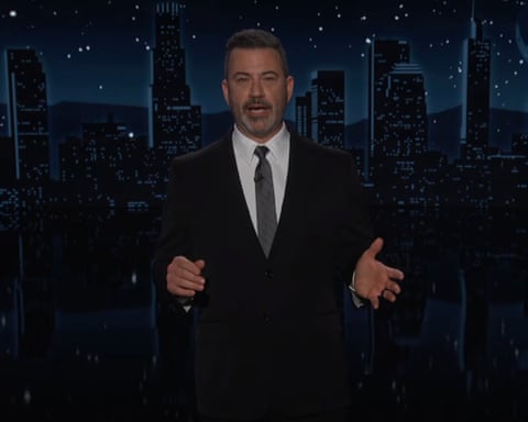 a man in a suit and tie speaks on a television set