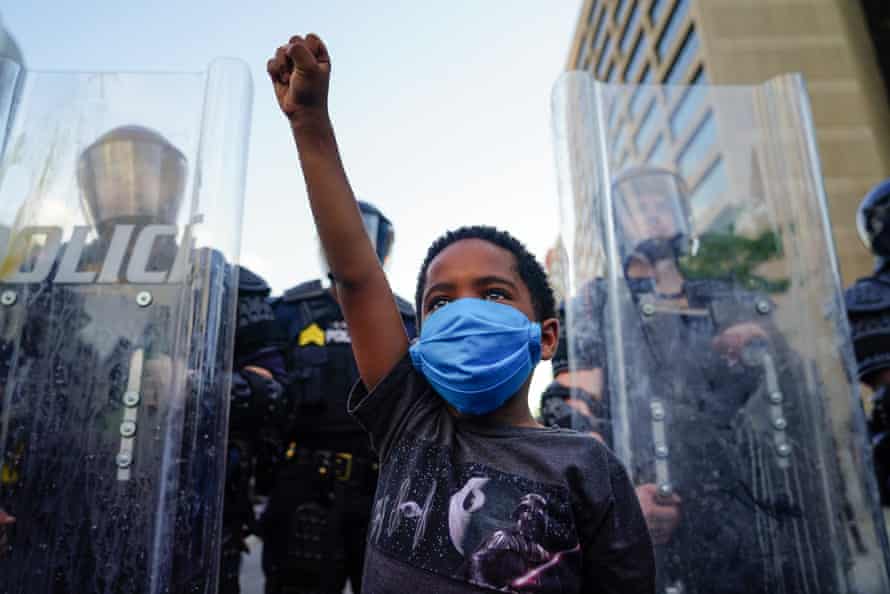 A young boy raises his fist for a photo by a family friend during a demonstration in Atlanta, Georgia.