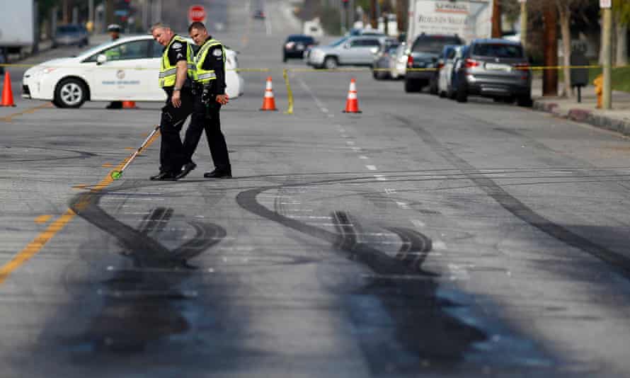 Police investigators survey skid marks at drag racing scene where two pedestrians were killed in Chatsworth, California.