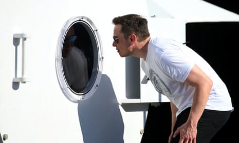 Elon Musk peers into a porthole at the SpaceX headquarters in Los Angeles