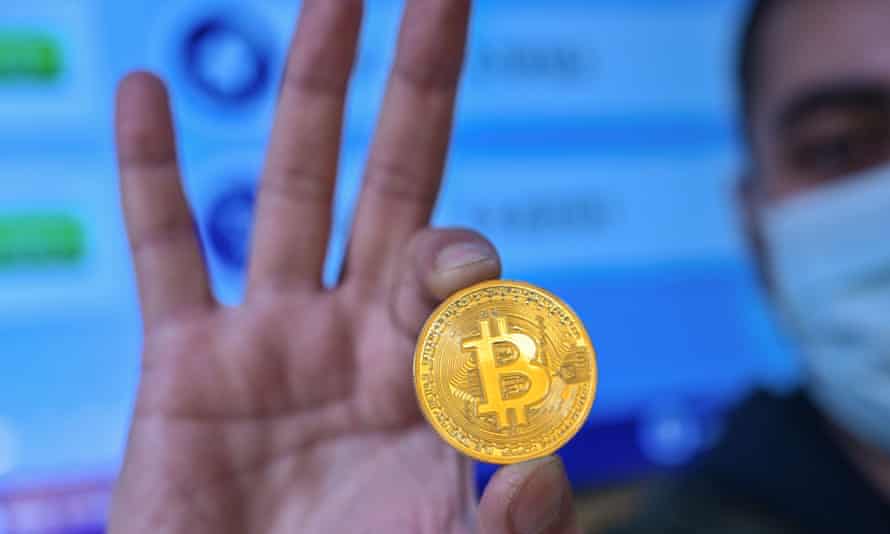 A man holds a physical imitation of a Bitcoin at a cryptocurrency exchange near the Grand Bazaar, Istanbul.