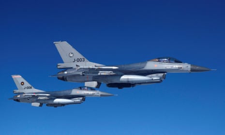 Dutch air force F-16 fighter jets fly alongside an aircraft simulating aerial interceptions