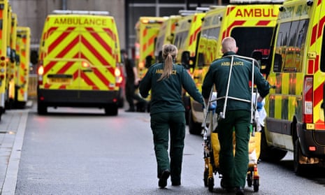ambulance workers and ambulances outside a hospital