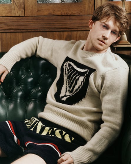 A model wears a unisex ivory coloured Guinness shield harp jumper