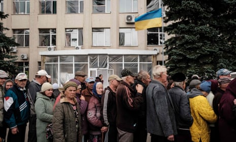 People wait in line for food and medical aide in the town of Lyman in Donetsk region on 5 October.