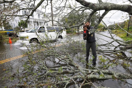 A volunteer cuts away a felled tree in Charleston, South Carolina