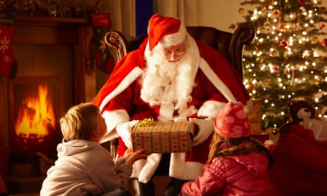 Santa Claus giving gifts to children by the fireside