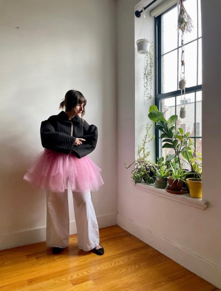 woman next to window wearing black jacket over tutu-like skirt