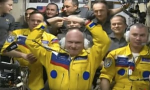 In this photo taken from video footage released by the Roscosmos Space Agency, Russian cosmonauts Оleg Аrtemiev, center, Denis Мatveev, right, and Sergei Korsakov are wearing yellow suits as they arrive at the ISS