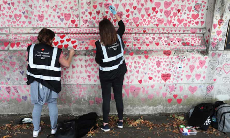 ‘We won’t let it fade’: bereaved call for UK Covid memorial to be preserved | London 2 Volunteers working on the wall.