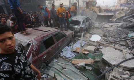 Palestinians look at the destruction after an Israeli strike in Rafah, G
