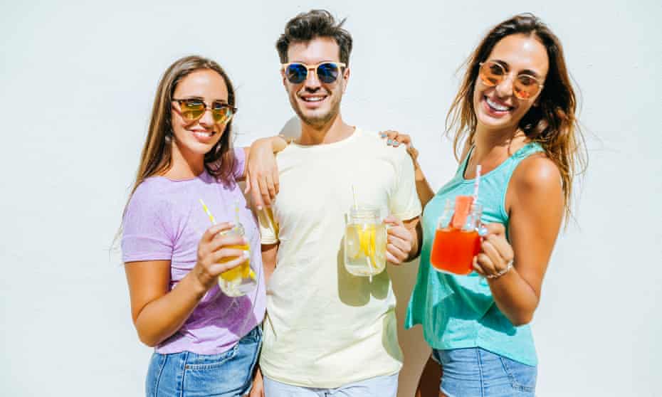 A man and two woman holding lemonades and looking happy