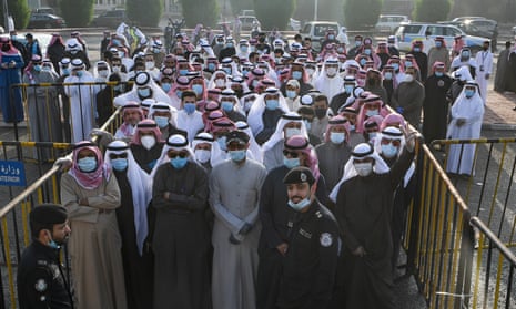People wearing protective masks arrive to cast their vote at a polling station in Kuwait City, Kuwait, on 5 December 2020. Due to the ongoing coronavirus pandemic, candidates campaigned primarily via social media.
