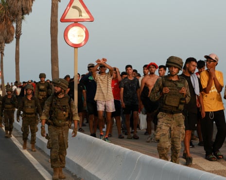 Migrants being escorted in Ceuta, Spain, 1 August 2026.