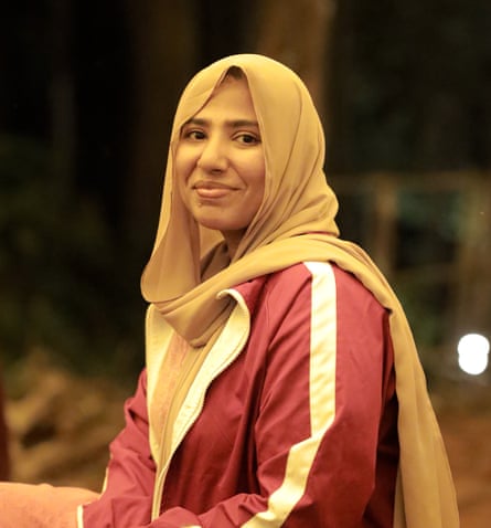 A youngish Indian woman in a headscarf smiles at the camera