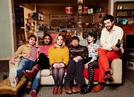 Young 00s-looking people sit on a sofa