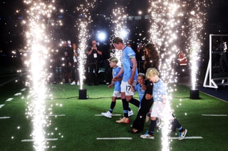 Kevin De Bruyne walks on to the pitch with his wife, Michèle, and children Suri, Mason and Rome for a farewell presentation after his last home match for Manchester City.