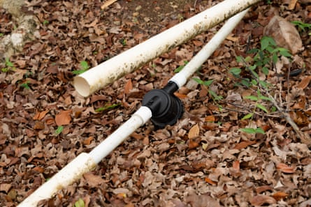 Plastic pipes sit on the ground, one totally diconnected