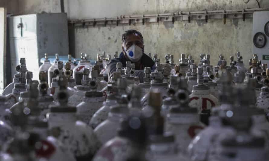 A hospital worker checks oxygen cylinders as India sets another global record on coronavirus cases. 
