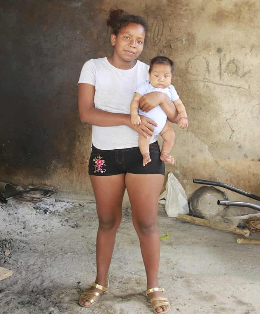 Hipolita’s granddaughter, Annette, holds her child in the family home.