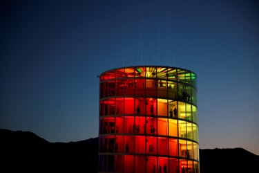 People walk around Spectre, a seven-storey rainbow tower installation