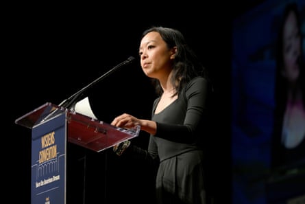 a woman in black dress speaks into microphone at lectern