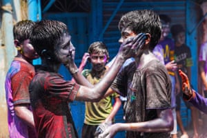 Dhaka, Bangladesh. Two boys paint each other’s faces with coloured powders to celebrate Holi at Sakhari Bazar