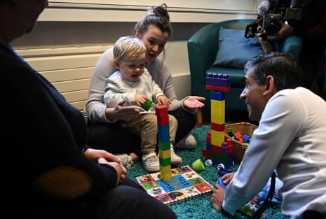 Rishi Sunak speaks with Giselle (centre) the mother of Seth, 6 months (unseen), and Brody, 2, during a visit to a family hub in St Austell.