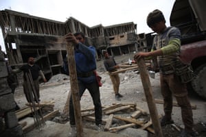 Iraqi workers repair a building on March 15, 2018 eight months after Iraqi forces liberated the city from the control of the Islamic State (IS) group fighters.