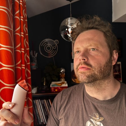 Writer Alan Martin using the Dyson HushJet Mini Cool fan in a room at home.