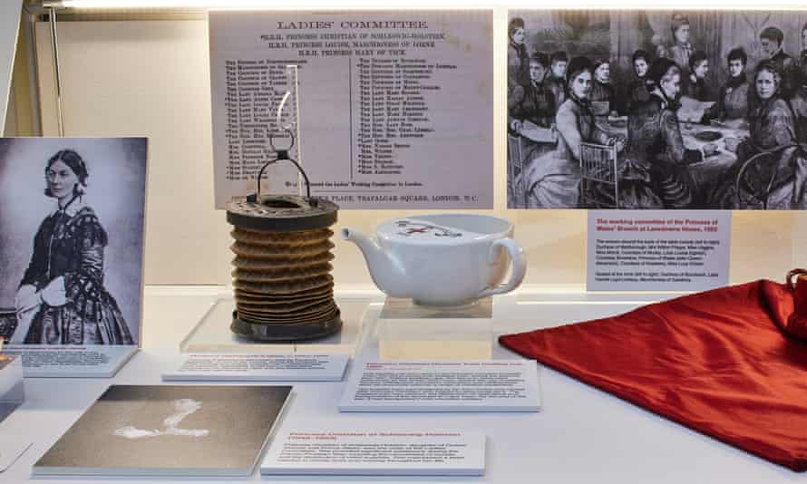 Photograph of a display case in a museum, featuring a collapsible concertina-style lamp with a handle