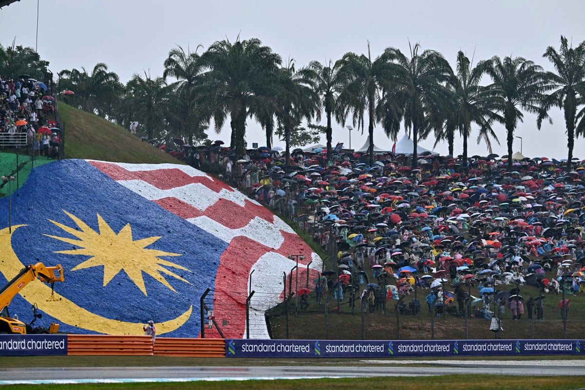 Spectators wait in the rain in Malaysia at the Bahrain GP