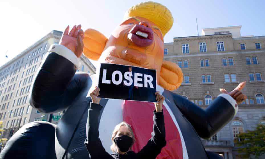 An anti-Trump protester in front of an inflatable caricature of Donald Trump in Washington DC on Friday.