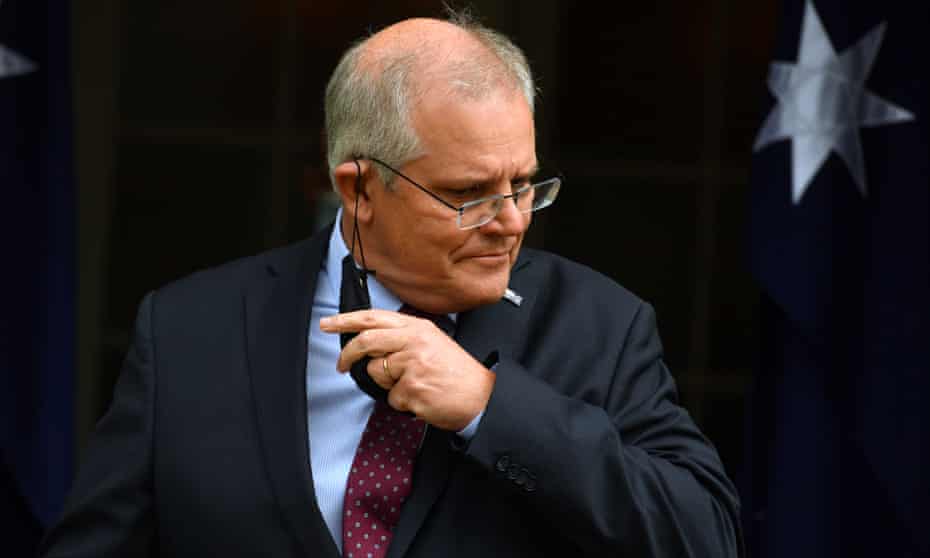 Prime Minister Scott Morrison taking off his mask as he arrives at a press conference at Kirribilli House