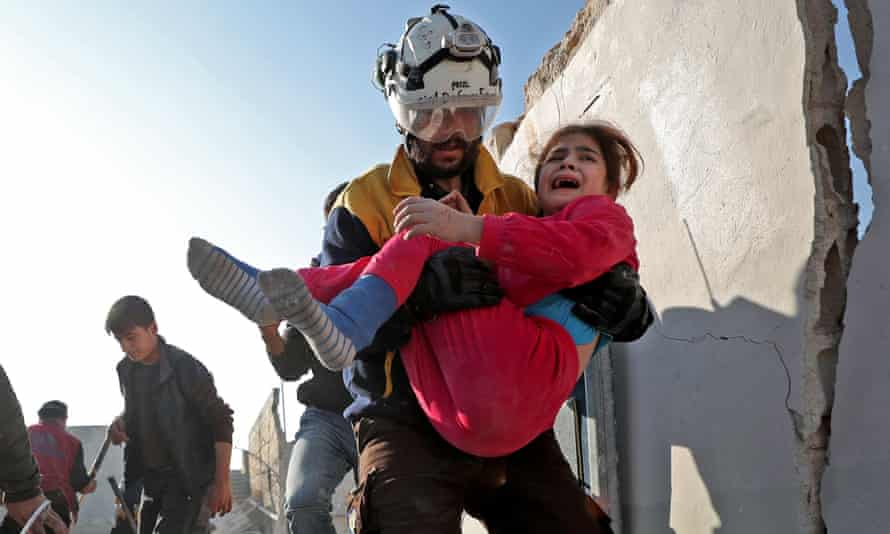 A member of the Syrian Civil Defence, also known as the White Helmets, carries a wounded girl after a reported Russian air strike in Idlib province