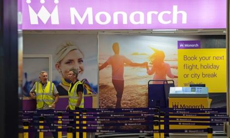 Airport staff at an otherwise deserted check-in area for Monarch Airlines at Birmingham airport