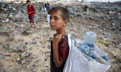 A Palestinian boy looks on as he scavenges for items at a dump site in Khan Younis in the southern Gaza Strip.